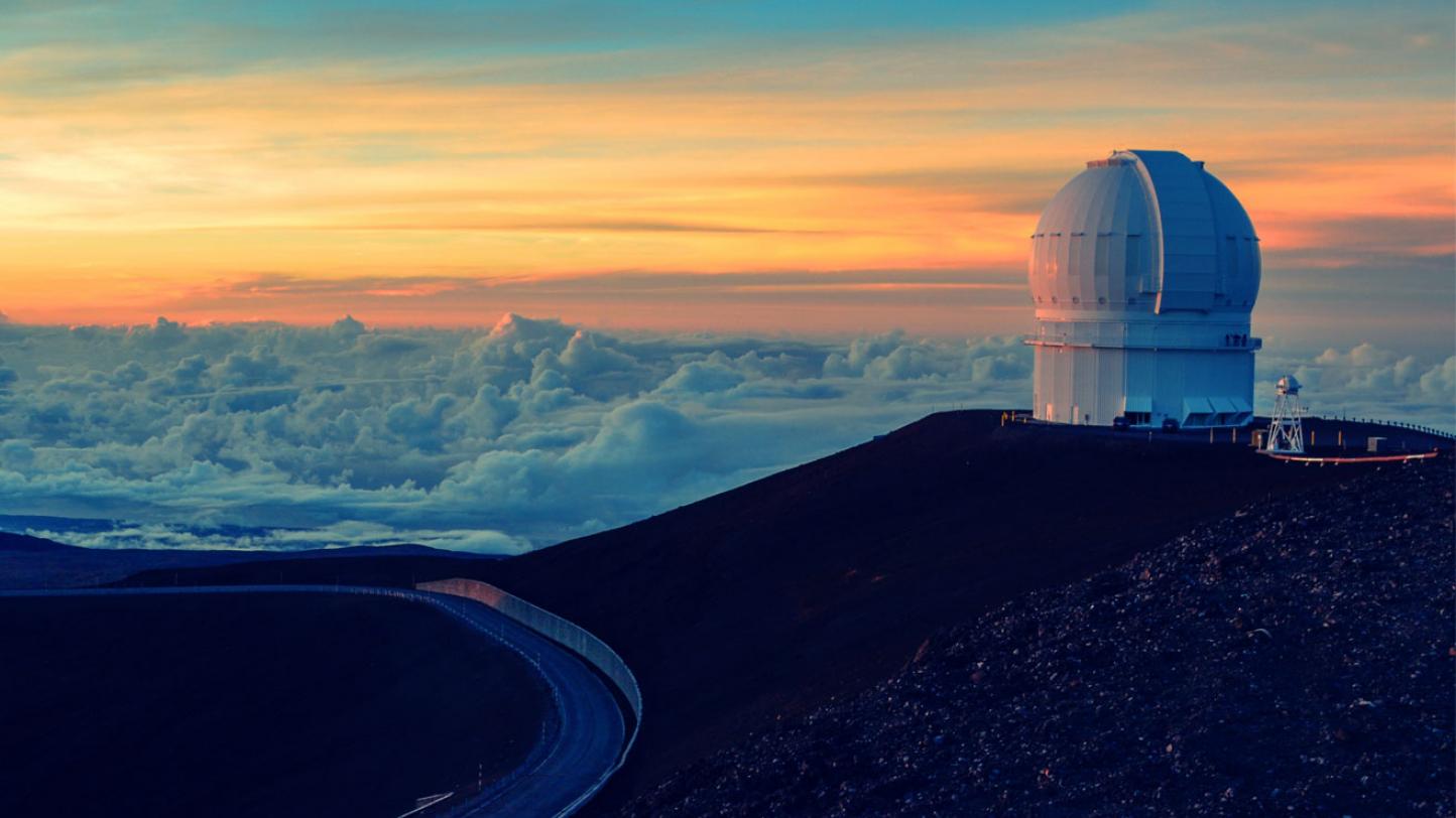 Single telescope on top of mountain above the clouds.