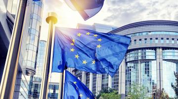 EU flags waving in front of European Parliament building in Brussels